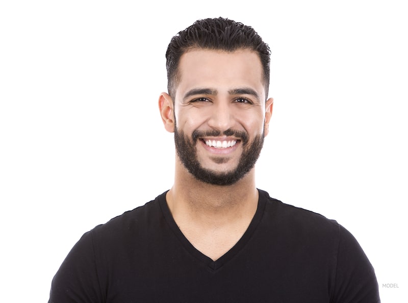  Man's face and bust, smiling and wearing a black t-shirt.