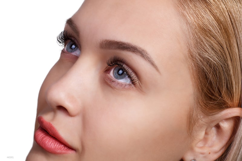 Close-up of woman's eyes and forehead against a white background.