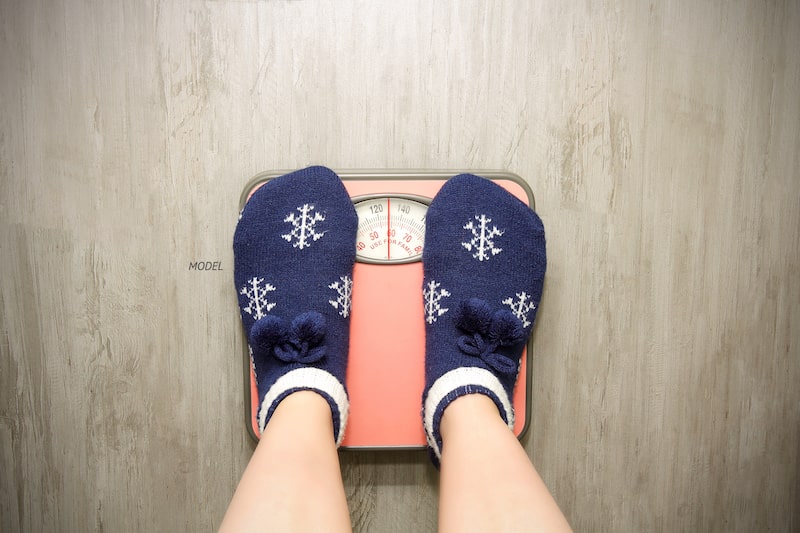 Woman standing on scale, wearing winter socks.