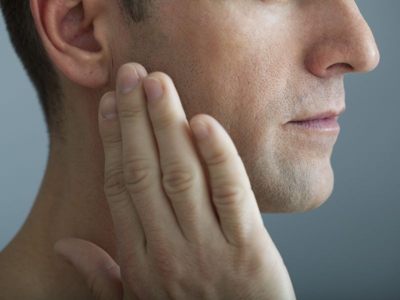 A man touching his cheek