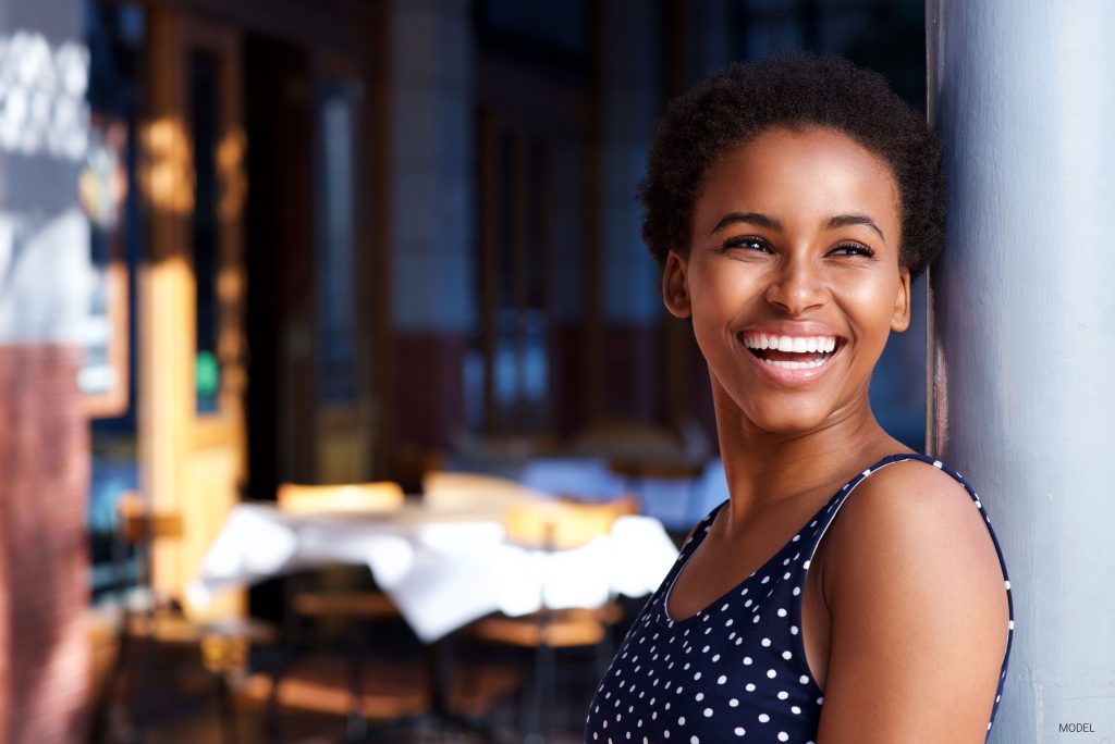 Beautiful young black woman smiling while looking away from the camera