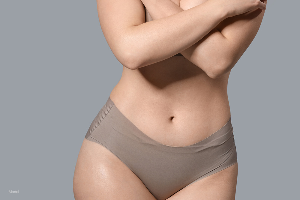 curvy woman with a flat stomach in gray underwear
